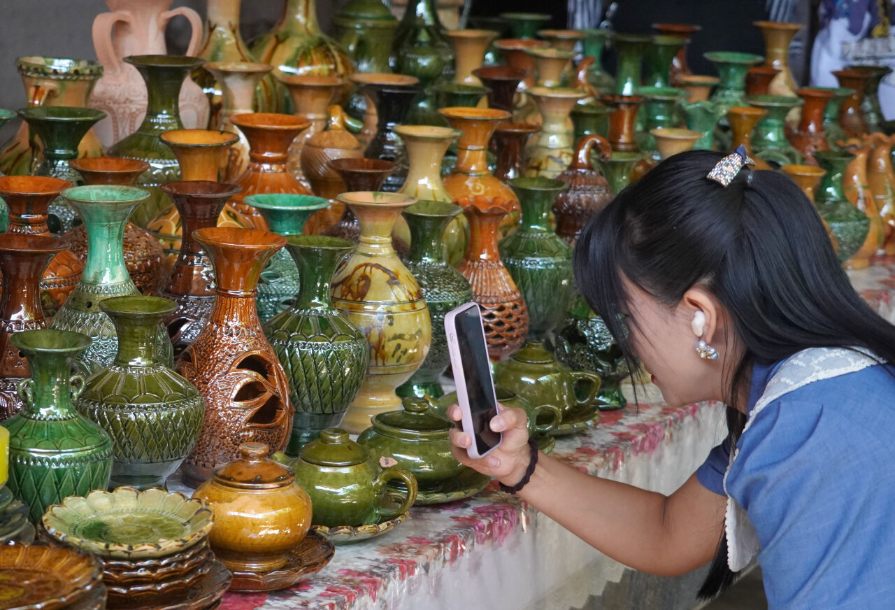 9月5日，游客在英吉沙县芒辛镇恰克日库依村拍摄土陶制品。